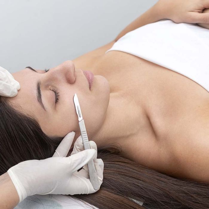 Woman receiving a dermaplaning facial treatment